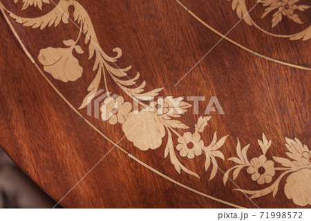 Decorative inlay carving on a wooden table 71998572
