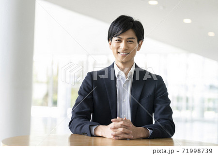 カメラ目線で微笑む若い男性 カメラ目線で微笑む若い男性 71998739