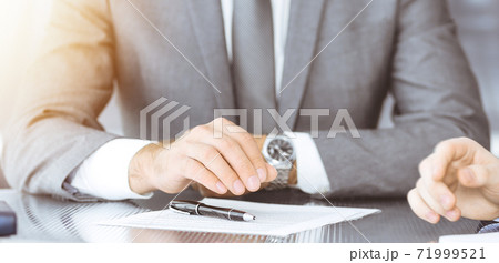 Unknown business people working together at meeting in modern office, close-up. Businessman and woman with colleagues or lawyers discussing contract at negotiation Unknown business people working together at meeting in modern office, close-up. Businessman and woman with colleagues or lawyers discussing contract at negotiation 71999521