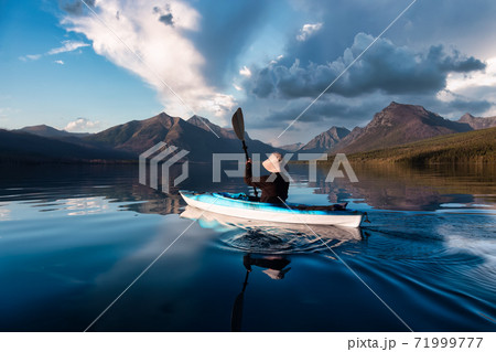 Adventurous Man Kayaking in Lake McDonald Adventurous Man Kayaking in Lake McDonald 71999777
