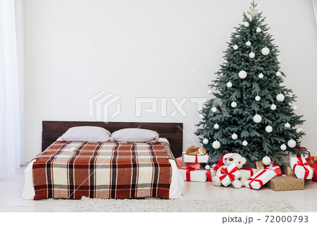 Christmas tree with gifts in the bedroom bed garlands the new year interior 72000793