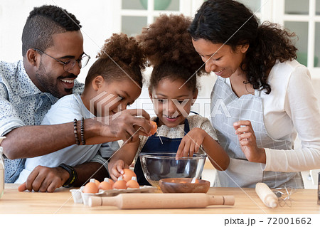 Loving friendly afro american family mixing dough for homemade pastries Loving friendly afro american family mixing dough for homemade pastries 72001662