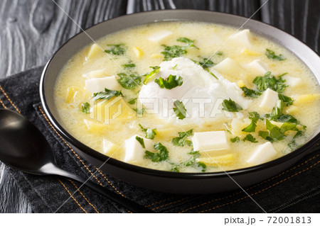 Delicious latino american chicken broth with potatoes, eggs, white cheese and cilantro close-up in a bowl. horizontal 72001813