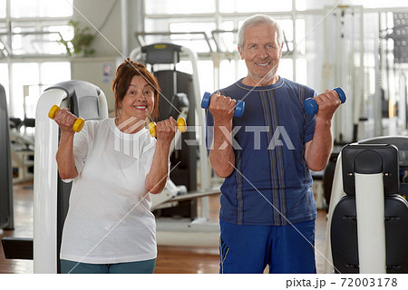 Satisfied senior couple with dumbells at sport club. Satisfied senior couple with dumbells at sport club. 72003178