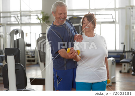 Portrait of smiling senior couple exercising in gym. Portrait of smiling senior couple exercising in gym. 72003181