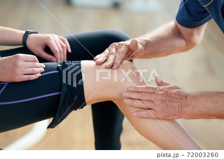 Close up woman suffering from pain in knee at gym. 72003260