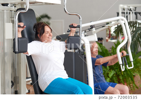 Smiling older woman working out at gym. 72003535
