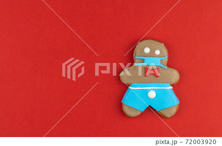 gingerbread man in a medical mask. Medical respiratory bandage face, surgical protective mask. gingerbread man in a medical mask. Medical respiratory bandage face, surgical protective mask. 72003920