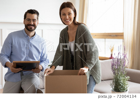 Portrait of happy couple unpack boxes moving together Portrait of happy couple unpack boxes moving together 72004134
