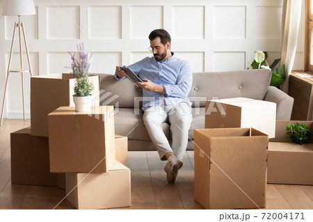 Caucasian man sit on couch using tablet 72004171