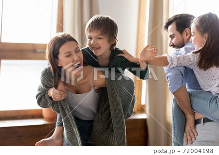 Overjoyed parents have fun playing with children 72004198