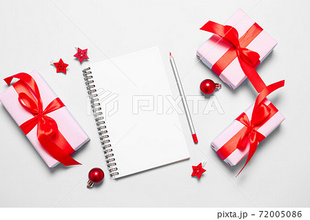 Planning and setting goals for the next year. New Year goals List 2021 with white notebook written plan. Christmas gift box wrapped in pink paper with red ribbon 72005086