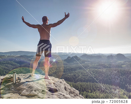 Shirtless sportsman raised arms to greeting nature Shirtless sportsman raised arms to greeting nature 72005628