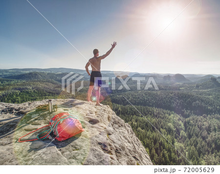 Shirtless sportsman Take off backpack and rope on cliff Shirtless sportsman Take off backpack and rope on cliff 72005629