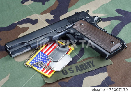 US ARMY branch tape M1911 handgun with dog tags on woodland camouflage uniform 72007139