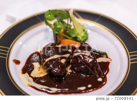 金色の淵の皿を飾るフレンチ料理の野菜と赤ワインソースで煮込んだ牛肉のブルギニョンのシチュー。 72008541