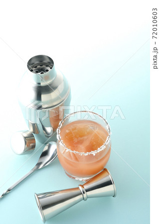 グラスの縁に塩が付いているピンクソルティドッグとカクテルシェーカーとメジャーカップ グラスの縁に塩が付いているピンクソルティドッグとカクテルシェーカーとメジャーカップ 72010603