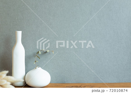 Home decor interior. Ceramic vase with dry plant on wooden table. Khaki green background 72010874