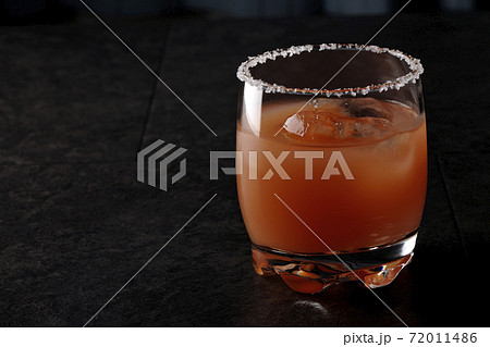 グラスの縁に塩が付いているピンクソルティドッグ 72011486