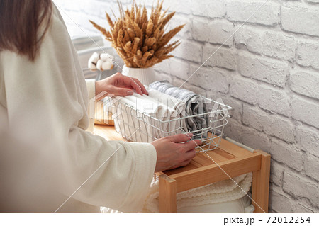 Woman beautifully put things into containers. Clothes storage. Woman beautifully put things into containers. Clothes storage. 72012254