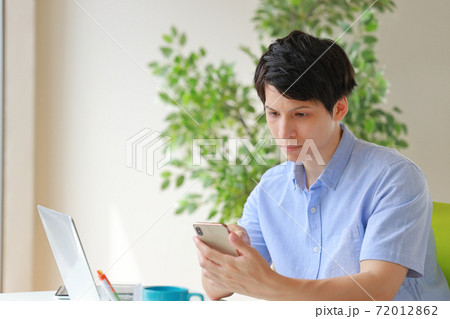 スマホを見て困惑の表情のビジネスマン スマホを見て困惑の表情のビジネスマン 72012862