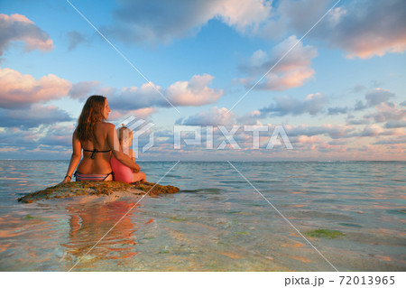 Young mother with happy daughter relax at sunset sea beach 72013965
