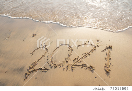 Sea wave wipe away 2021 Text writing on white sand Tropical beach in the morning Beautiful light sunrise on beach and wave crashing on sandy shore. Sea wave wipe away 2021 Text writing on white sand Tropical beach in the morning Beautiful light sunrise on beach and wave crashing on sandy shore. 72015692