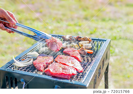 屋外のオープングリルで牛肉を網焼きしている様子 72015766
