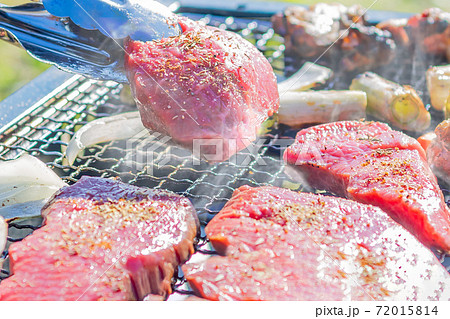 屋外のオープングリルで牛肉を網焼きしている様子 72015814