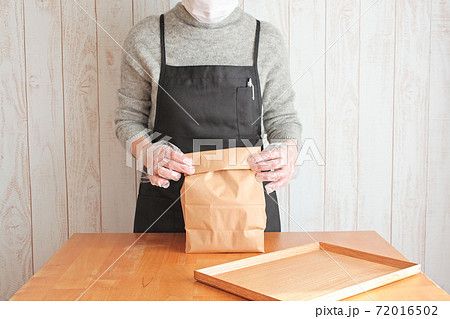 商品を紙袋に入れる女性店員 商品を紙袋に入れる女性店員 72016502