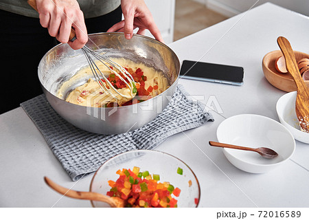Woman in kitchen cooking a cake. Hands beat the dough with mixer 72016589
