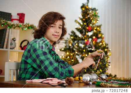 Teenage boy making Christmas decoration 72017248