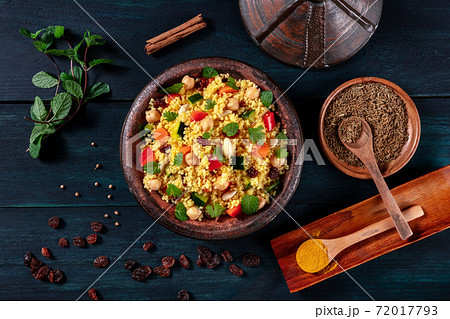 Traditional couscous in a tajine, shot from the top with spices and herbs 72017793