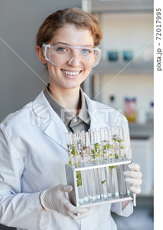 Smiling Female Scientist Holding Test Tubes in Bio Lab 72017995