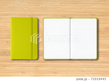 Lime green closed and open lined notebooks on wooden background 72019445