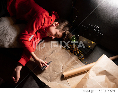 Teenage boy sleeping sweetly on long letter to Santa 72019974