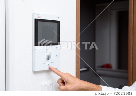 マンションのインターホンをタッチする男性　テレビドアホン 72021903
