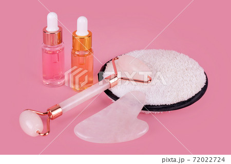 Jade face roller and Gua sha stone for facial massage. Home skin care anti-aging tools, face serum bottle, massage roller. Natural organic essential oil, skincare beauty product. Jade face roller and Gua sha stone for facial massage. Home skin care anti-aging tools, face serum bottle, massage roller. Natural organic essential oil, skincare beauty product. 72022724