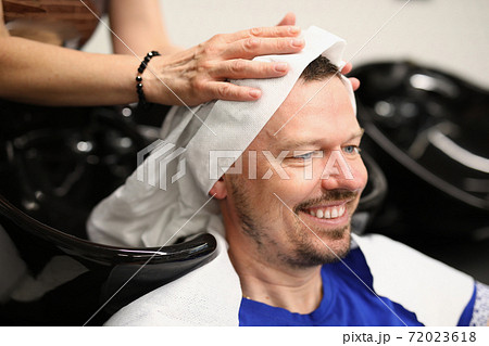 Master washes his head in barbershop closeup 72023618