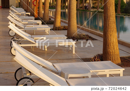 【ヨルダン】死海、リゾートホテルのプールサイドに並ぶ夕暮れで人気の無くなったビーチチェア 【ヨルダン】死海、リゾートホテルのプールサイドに並ぶ夕暮れで人気の無くなったビーチチェア 72024642