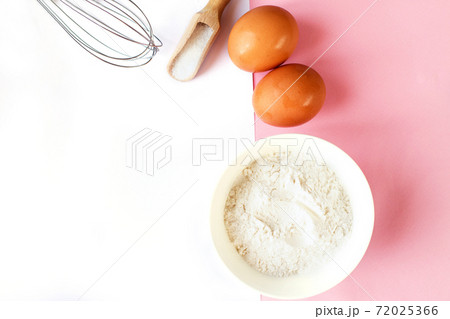 Ingredients for cooking baking - flour, egg, sugar, rolling pin on pink background. Concept of cooking dessert. 72025366