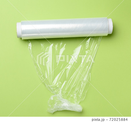 roll of transparent cling film for packaging products, green background 72025884
