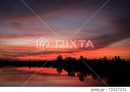 Sunset over lake with red orange sky. 72027251