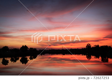 Sunset over lake with red orange sky. 72027253