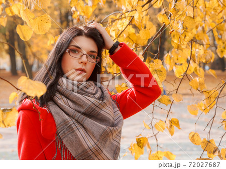 portrait of young girl in a red coat standing on the alley portrait of young girl in a red coat standing on the alley 72027687