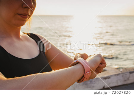 Young woman checking her heart rate at fitness tracker. Young woman checking her heart rate at fitness tracker. 72027820