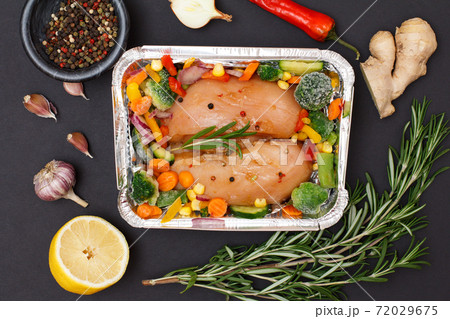Raw chicken breasts or fillet in metal container with ingredients. Raw chicken breasts or fillet in metal container with ingredients. 72029675