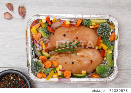 Raw chicken breasts or fillet in metal container with ingredients. Raw chicken breasts or fillet in metal container with ingredients. 72029678