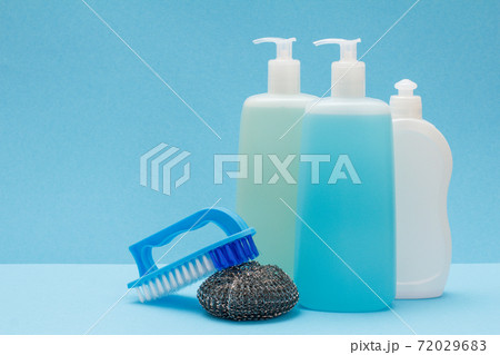 Bottles of dishwashing liquid, brush and sponge on blue background. 72029683