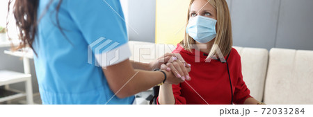 Doctor in uniform holds hand of sick young woman in wheelchair portrait Doctor in uniform holds hand of sick young woman in wheelchair portrait 72033284